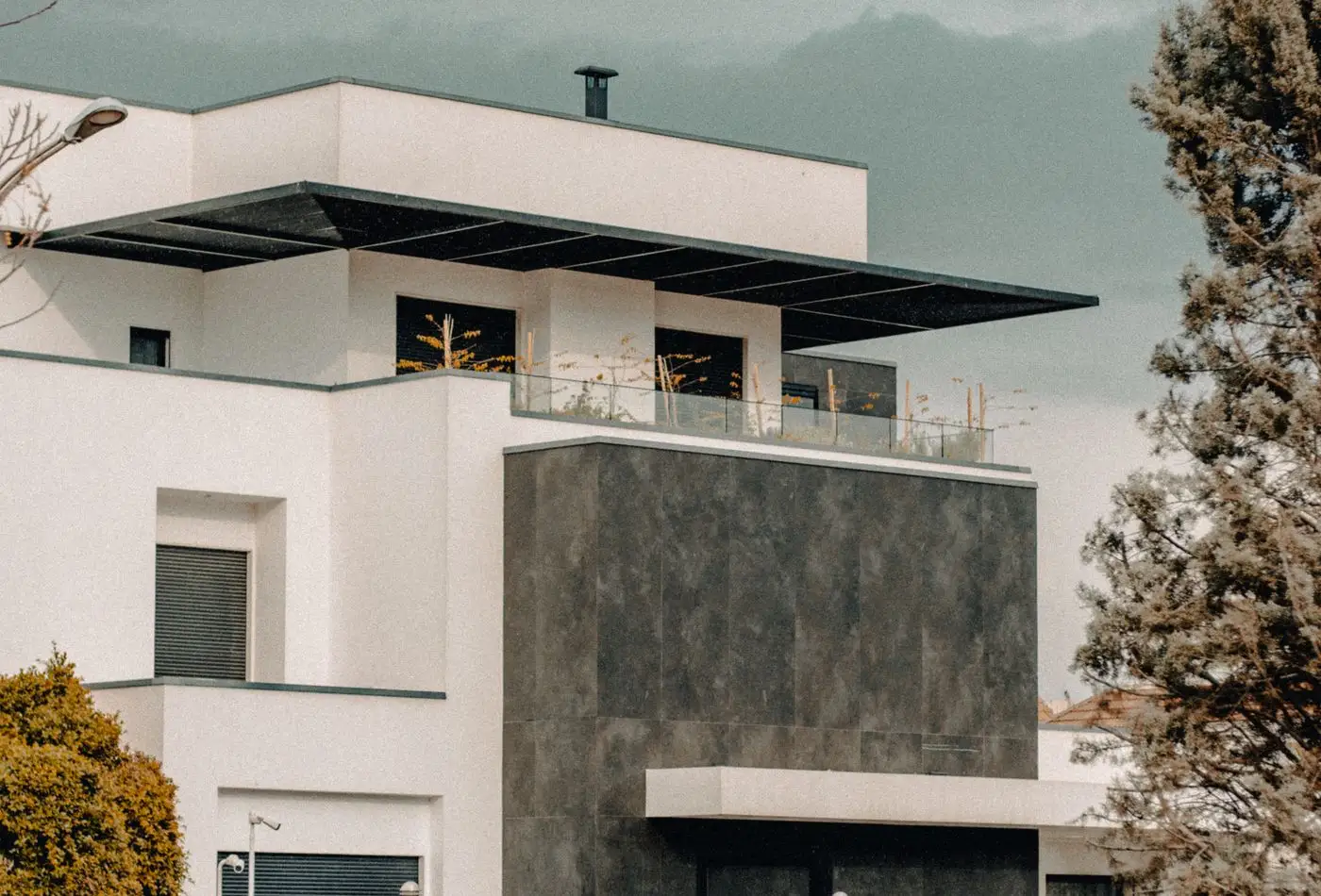 Vivienda de obra nueva con volumen de piedra oscura y terraza en cubierta