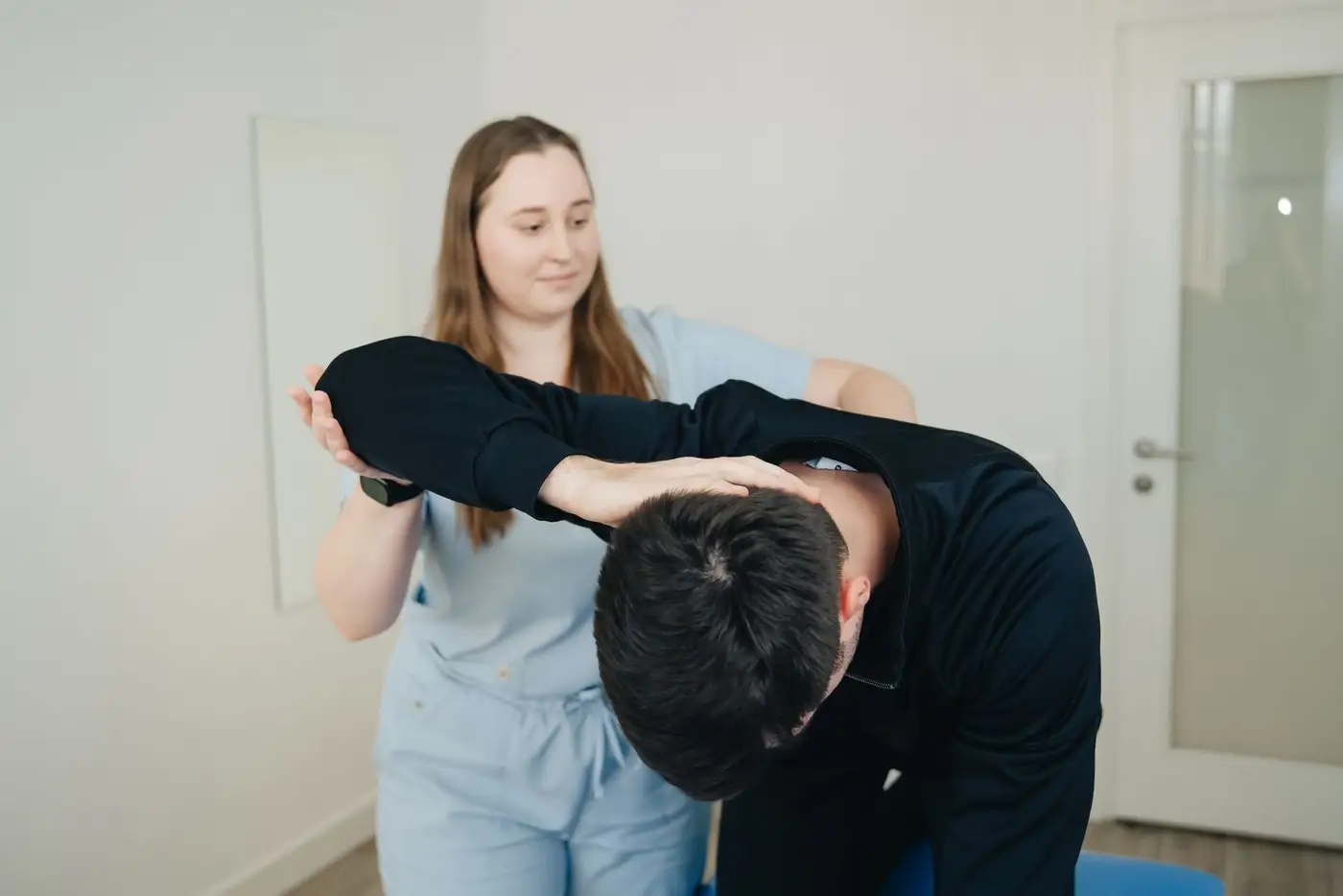 Fisioterapeuta de Fisio Vital movilizando el hombro de un paciente en consulta