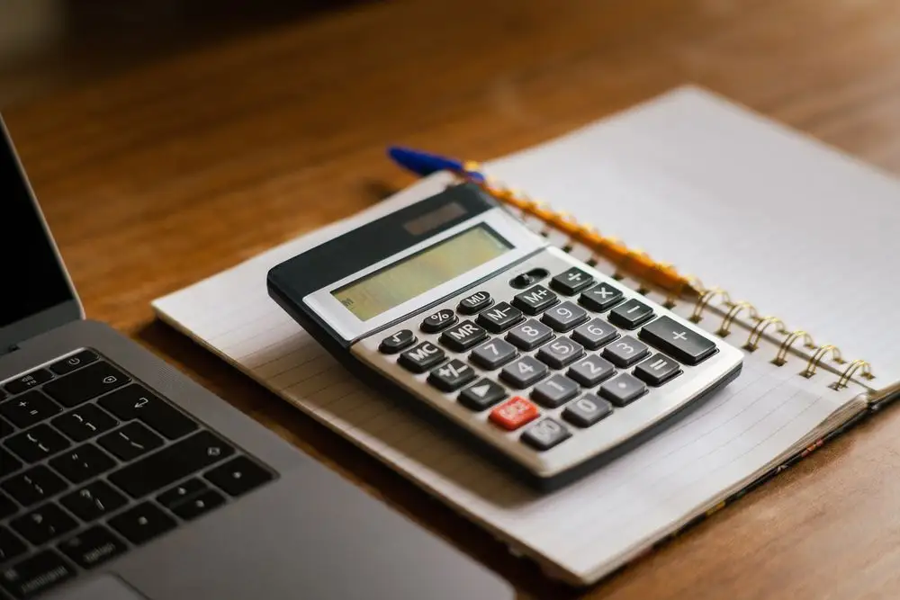 Calculadora y cuaderno de cuentas sobre el escritorio del despacho